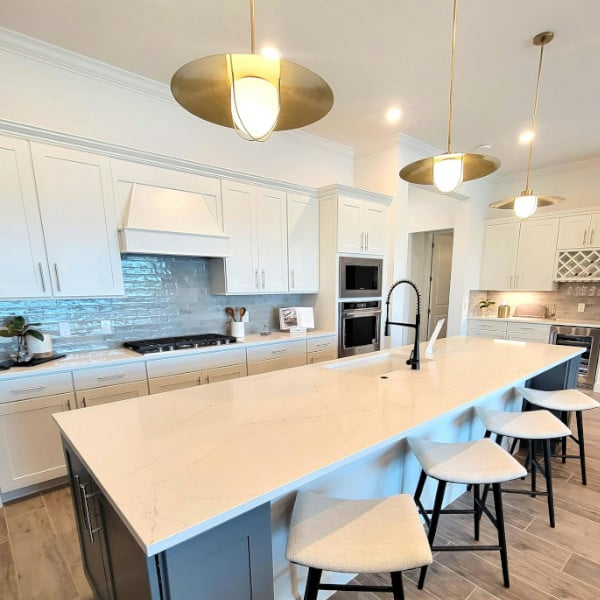 Modern light fixtures above a modern kitchen island and breakfast bar