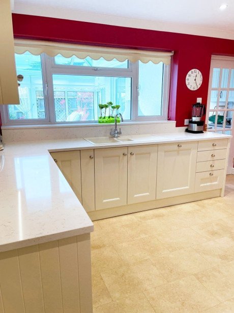 White kitchen with pink accent character on the walls